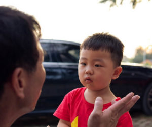 A young boy engages in conversation with his father, both appearing attentive and connected.