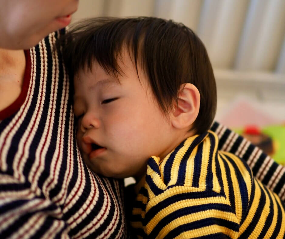 A woman gently cradles a child in her arms, showcasing a tender moment of care and affection.