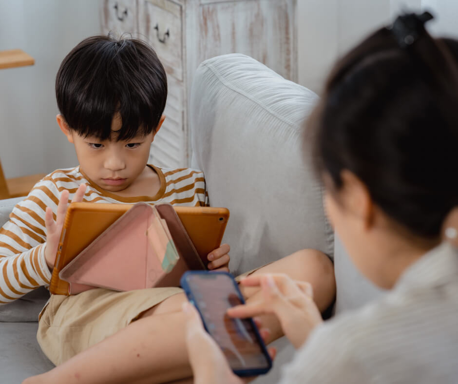 A woman and a child sitting together on a cozy couch, sharing a moment of relaxation and connection.