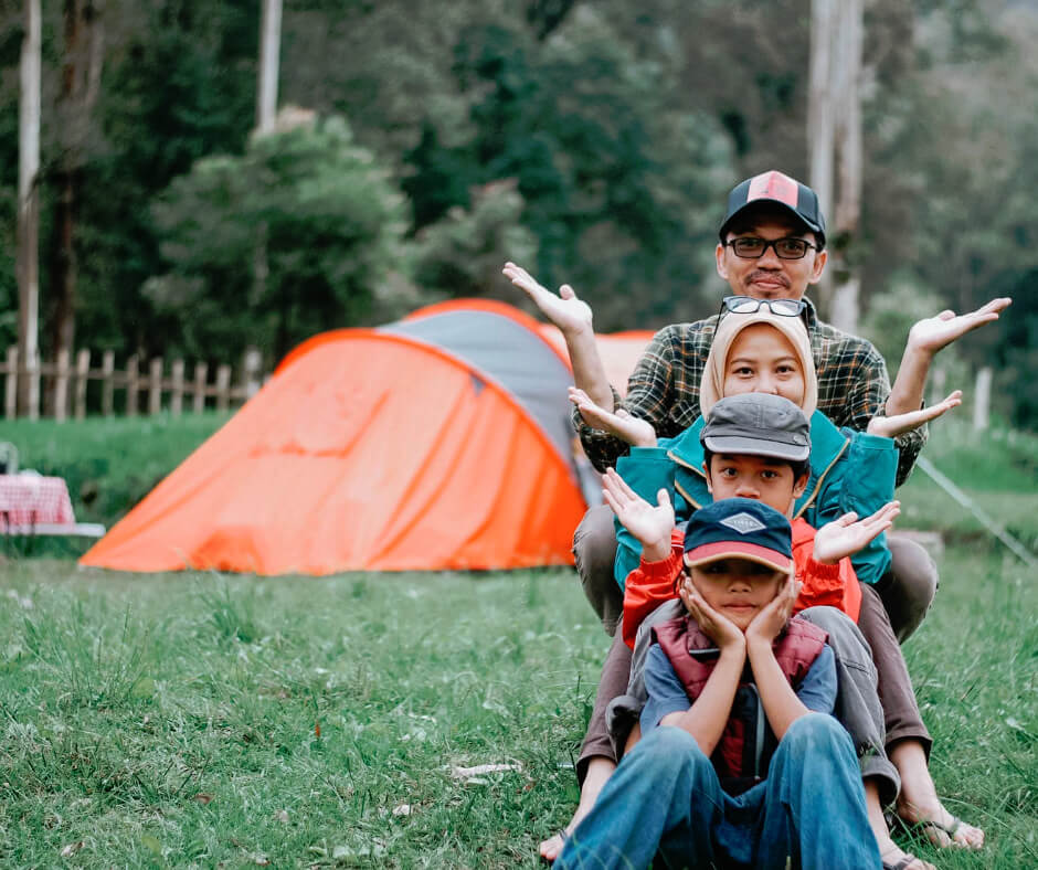 Family camping outdoors with kids enjoying a digital detox weekend away from screens in nature